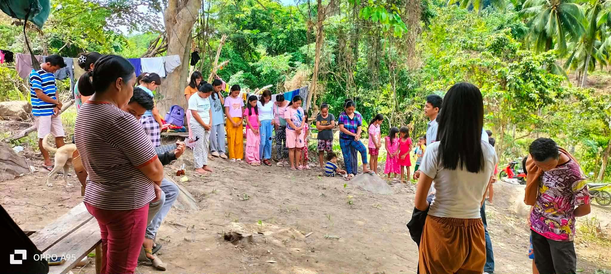 Community members gathered outdoors along a rural path